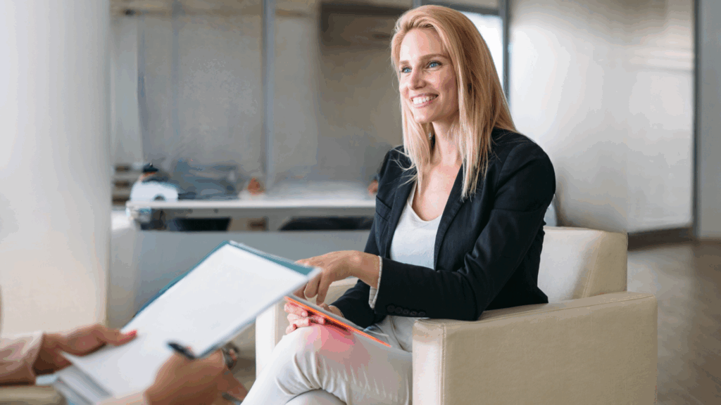 Donna manager sorridente in ufficio, simbolo di leadership e consapevolezza.